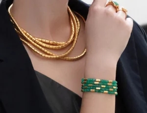 An image of a woman wearing jewelry by Gurhan: necklace, rings, and bracelets.